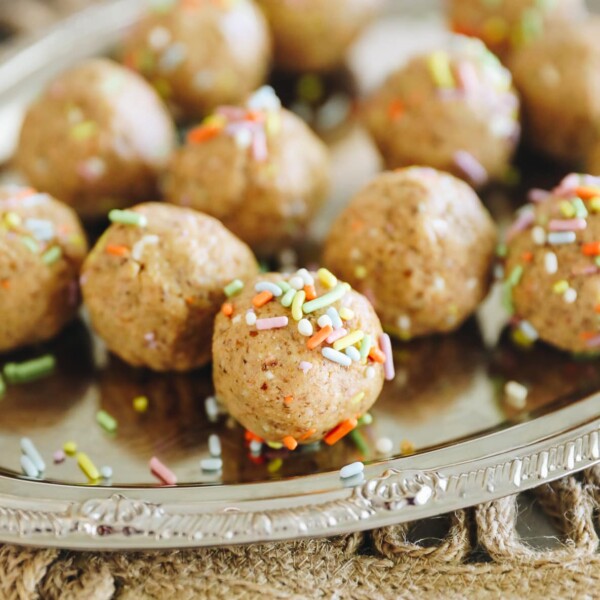 no-bake cake batter protein balls, covered in sprinkles on a silver platter.