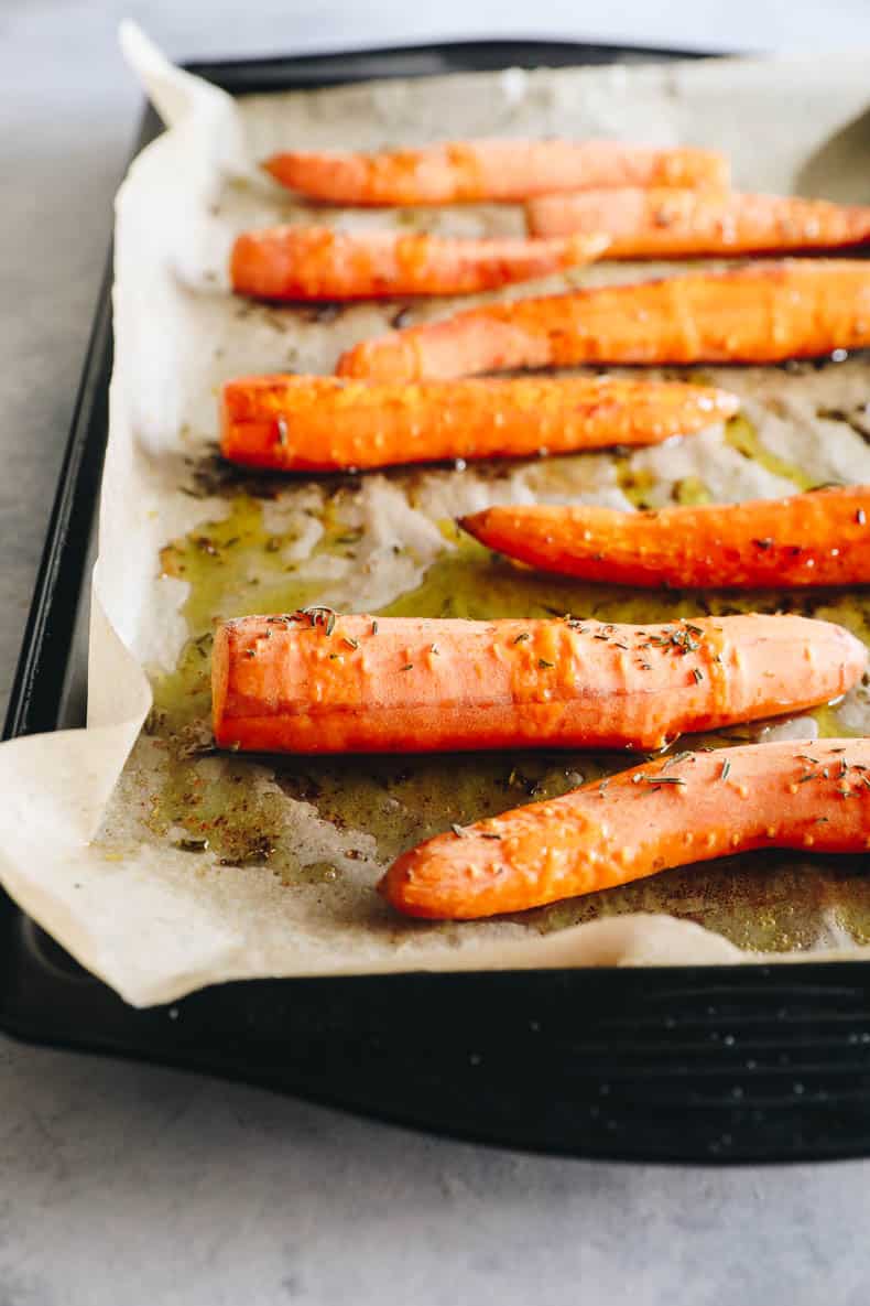 roasted carrots with salt and rosemary on a sheet pan