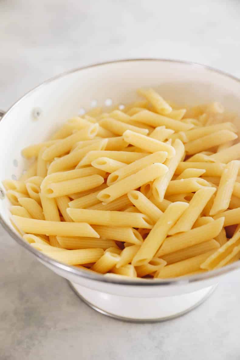 cooked penne strained in a colander.