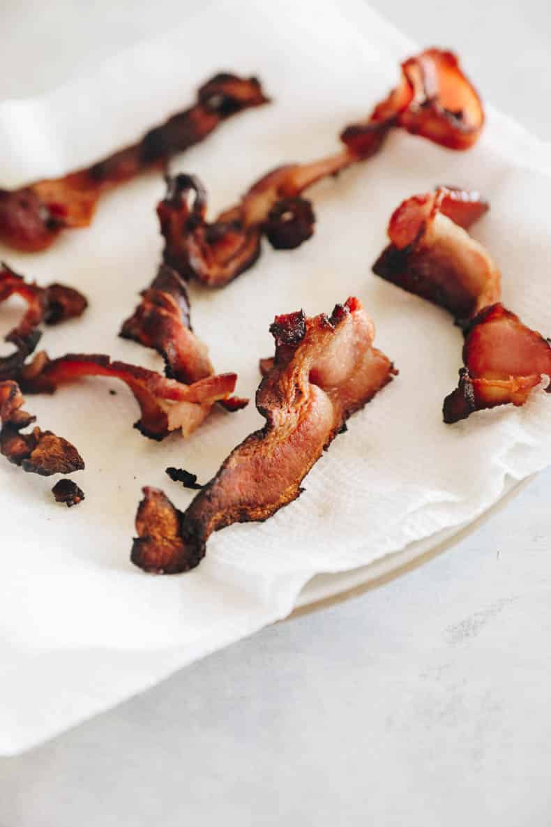 bacon drying on a plate with paper towel.