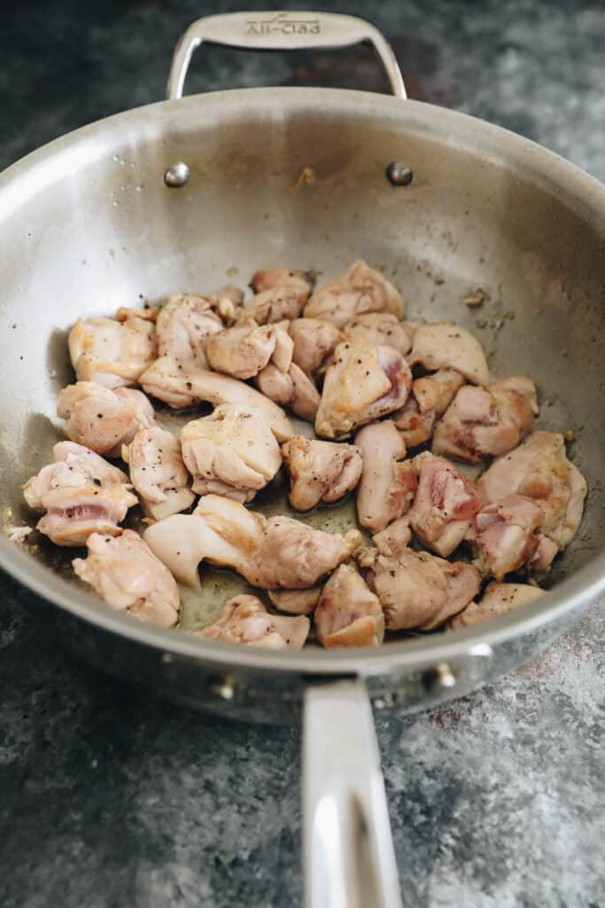 Cooked chicken thighs in a wok.