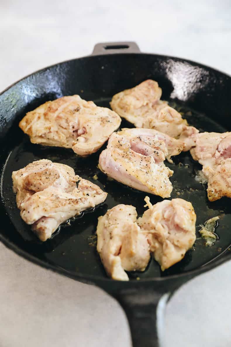 cooked chicken thighs in a cast iron