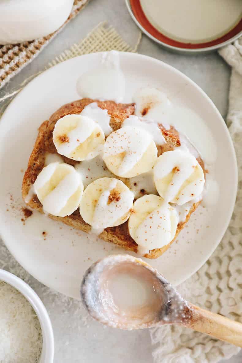 Peanut butter banana toast with homemade coconut butter drizzled on top.