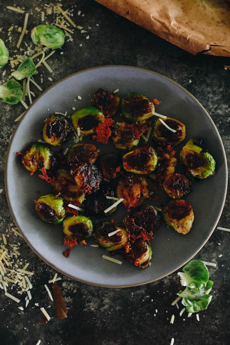 crispy smashed brussel sprouts with parmesan on a blue plate.