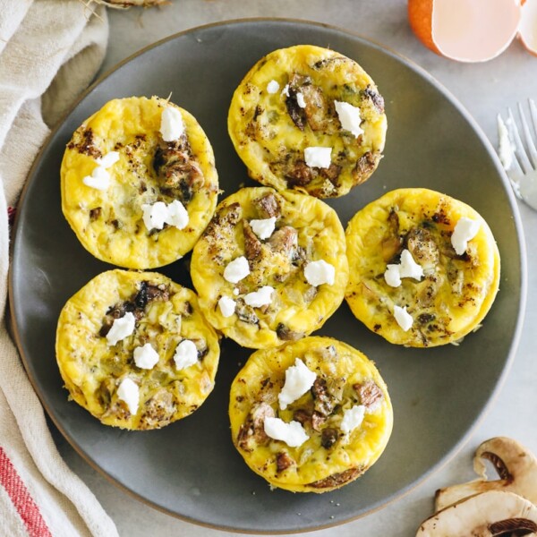 Overhead shot of a plate of egg muffins topped with goat cheese.