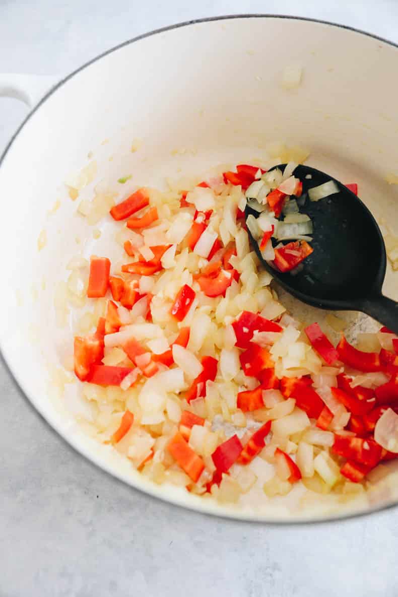 onions, garlic and bell pepper cooking in a dutch oven.