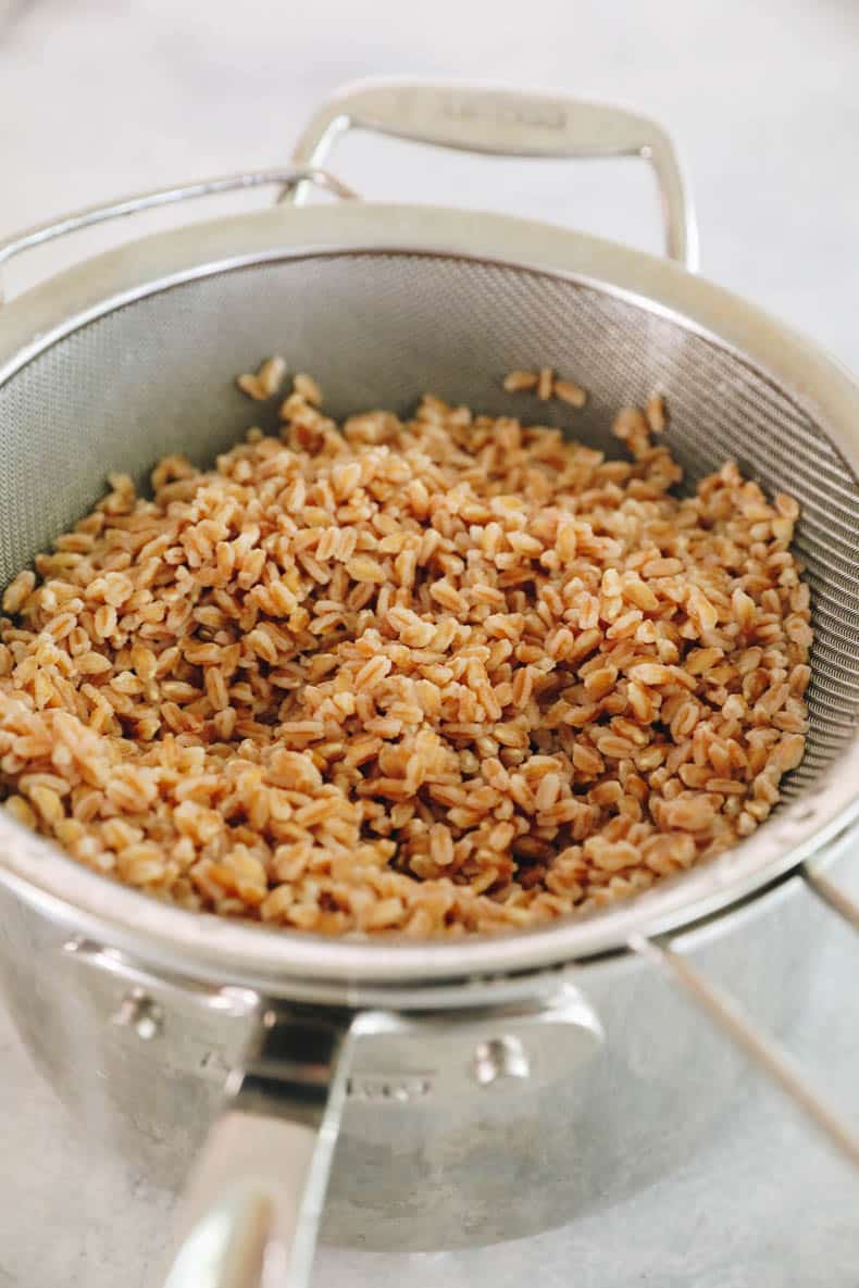 cooked farro in a strainer