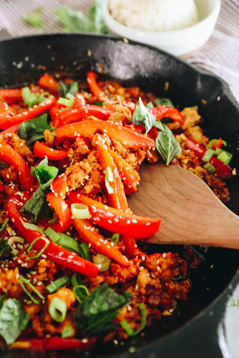 Serving spoon with chicken and bell peppers in a gochujang marinade.