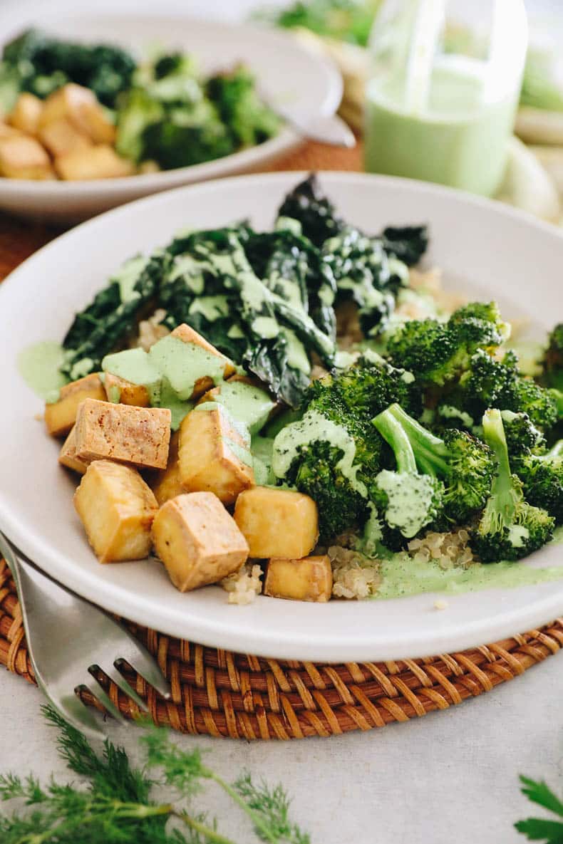 green goddess bowls in a white shallow bowl with quinoa, broccoli, kale and tofu.