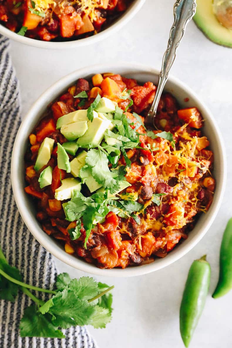 overhead image of a healthy chili recipe in a white bowl with a silver spoon.