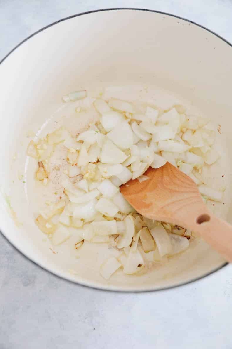 sauteed onions and garlic in a white dutch oven.