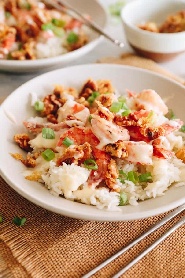 Honey walnut shrimp over rice in a white bowl.