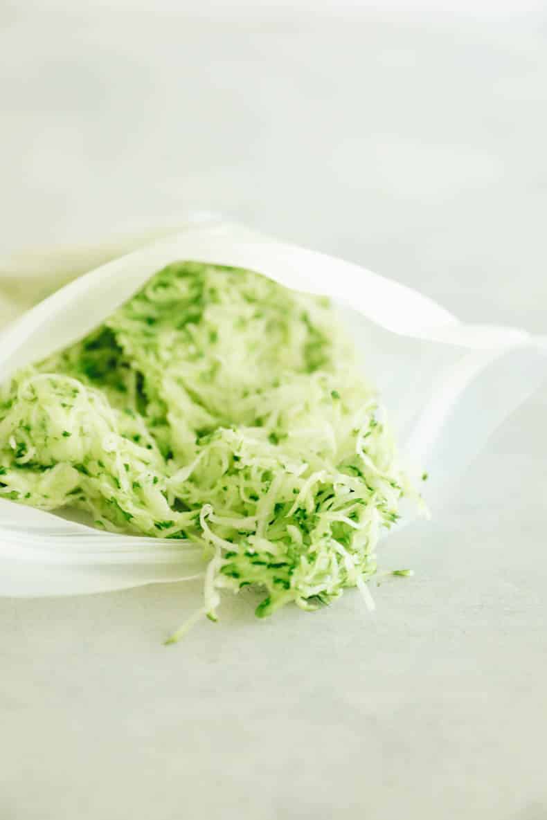 frozen shredded zucchini in a reusable freezer bag.