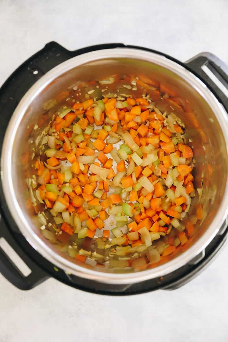 sauteing the base of Instant Pot Lentil soup including carrots, celery, onions and garlic in an Instant Pot.