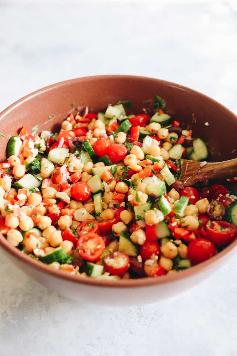 mediterranean salad recipe in a big brown bowl mixed together.