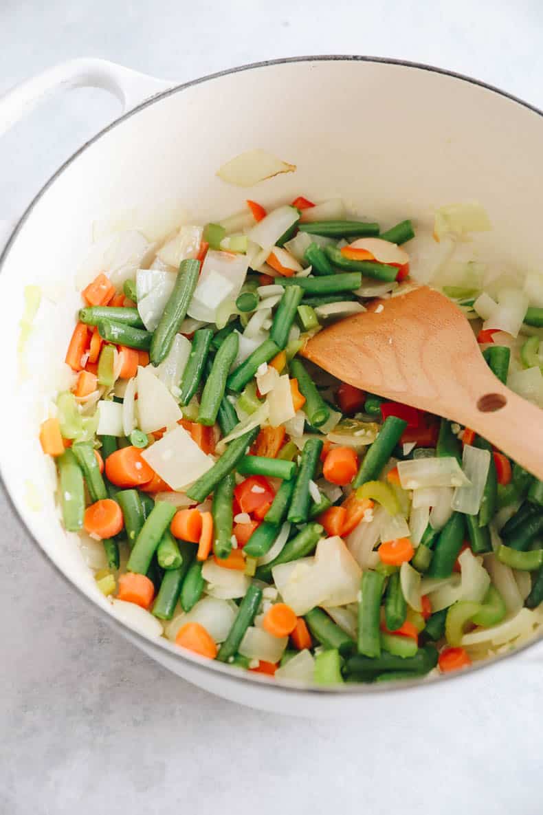 Large dutch oven with sauteed vegetables.