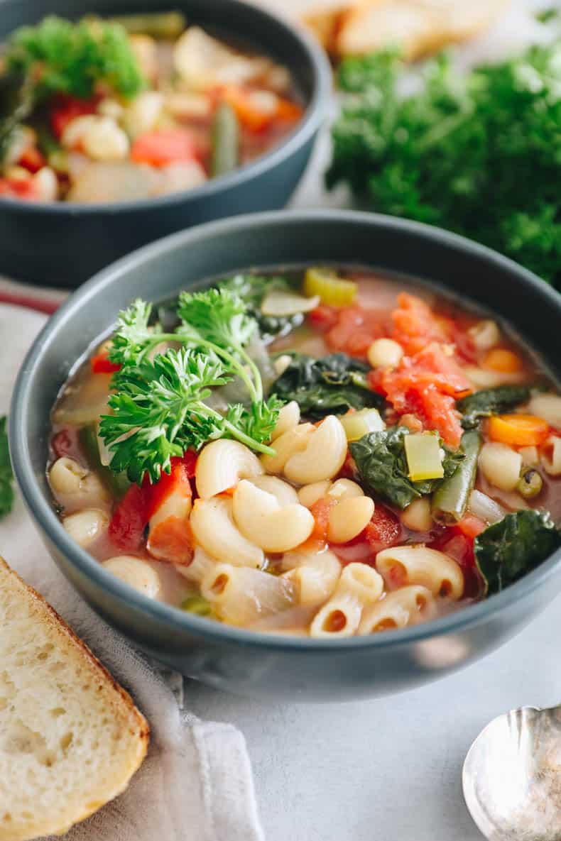 Minestrone soup in a blue bowl.