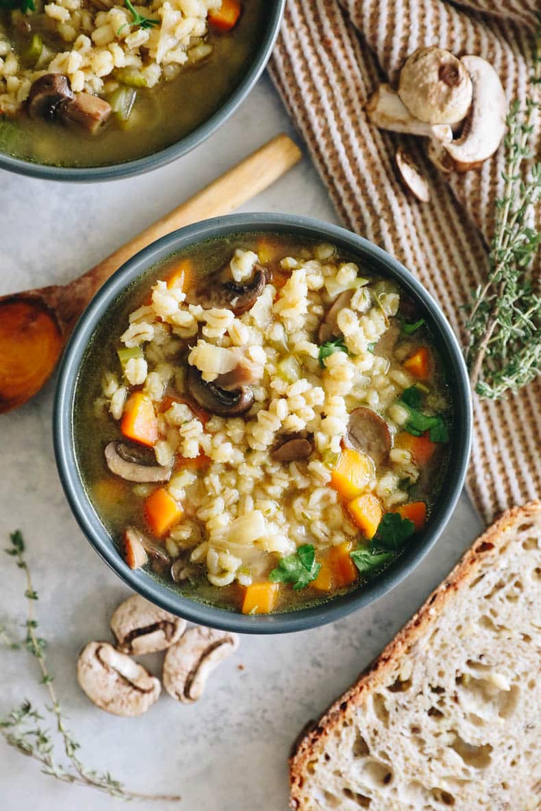 overhead photo of soup in blue bowls with a side of crusty bread.