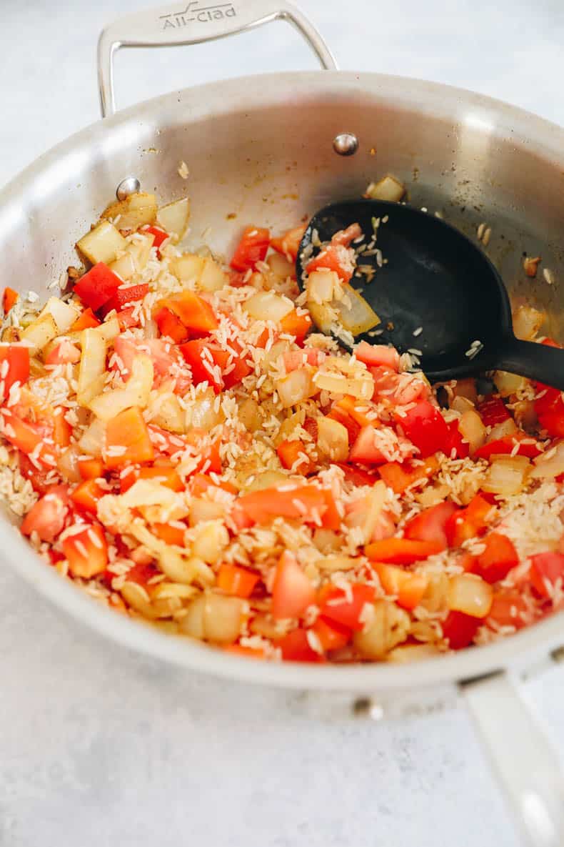 Rice and veggies in a large pot for one skillet paprika chicken and rice.