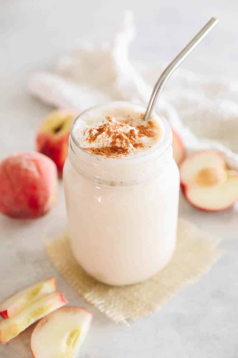 Peach smoothie in a mason jar sprinkled with cinnamon.