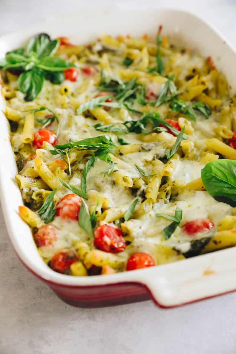 Pesto pasta bake in a red casserole dish