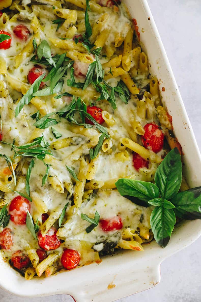 Close-up overhead photo of pesto pasta in a baking dish.