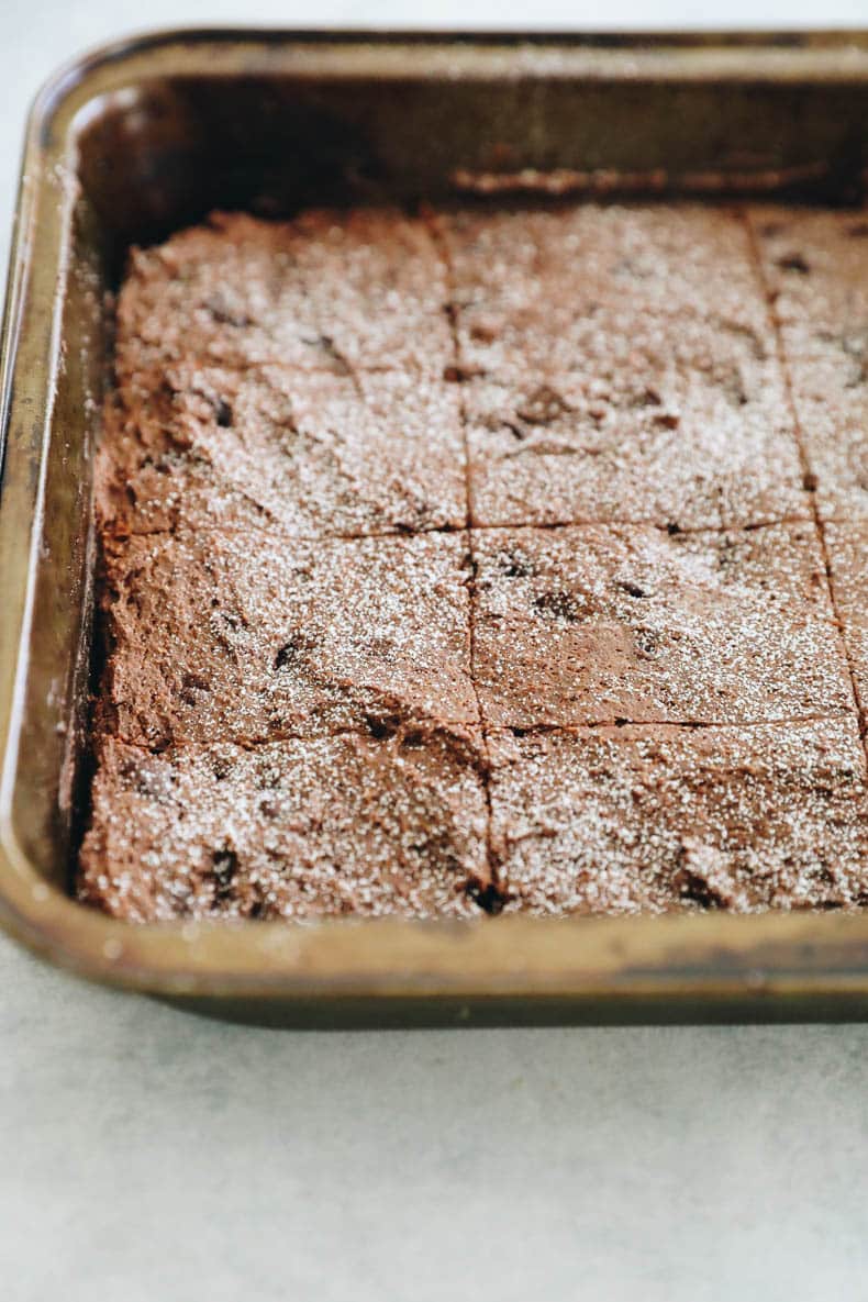 protein brownies in a pan and topped with powdered sugar.