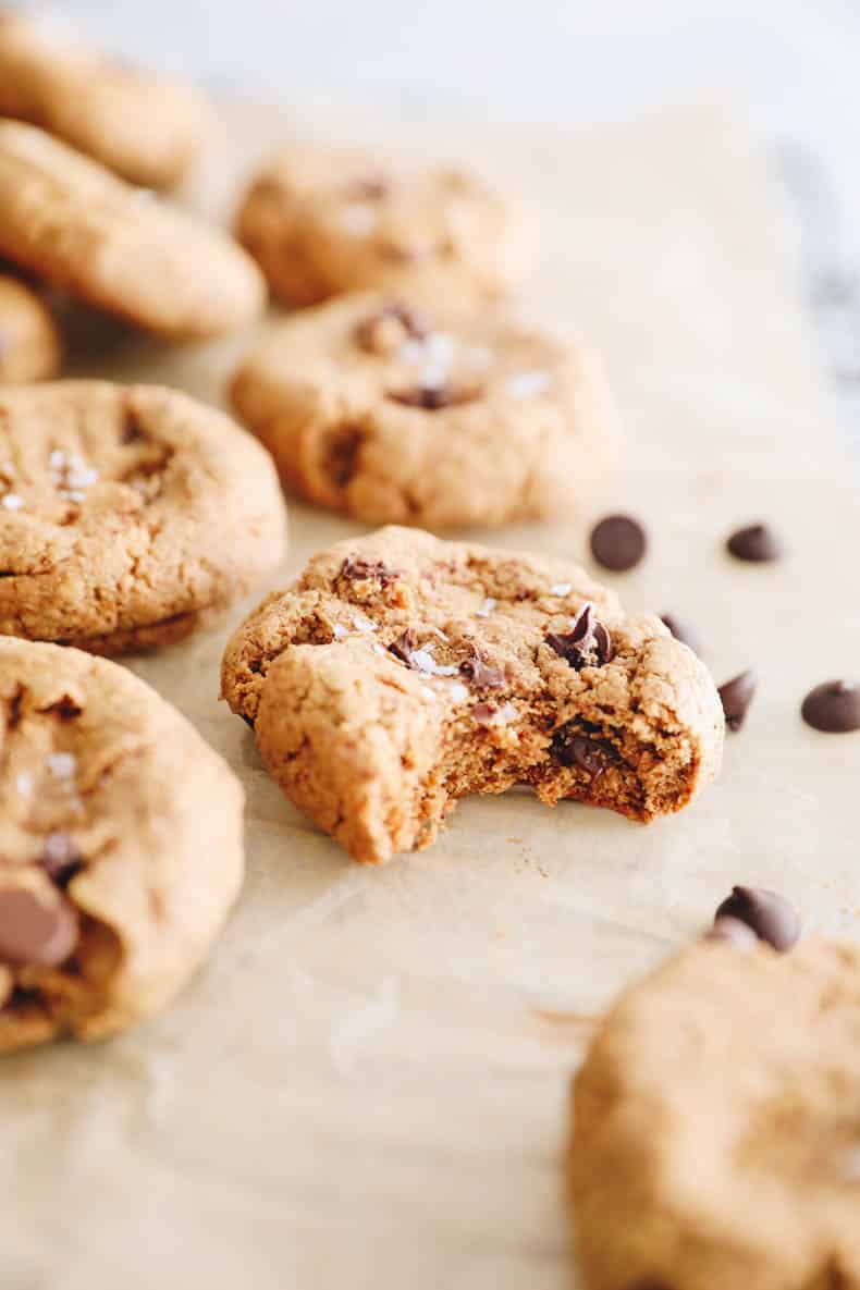 close up of a chocolate chip cookie with a bite taken out of it.