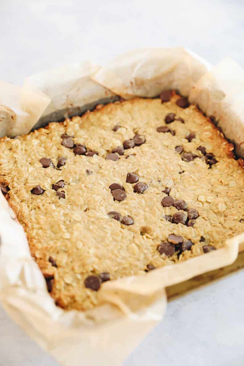 baked protein granola bars in a parchment paper lined baking pan.