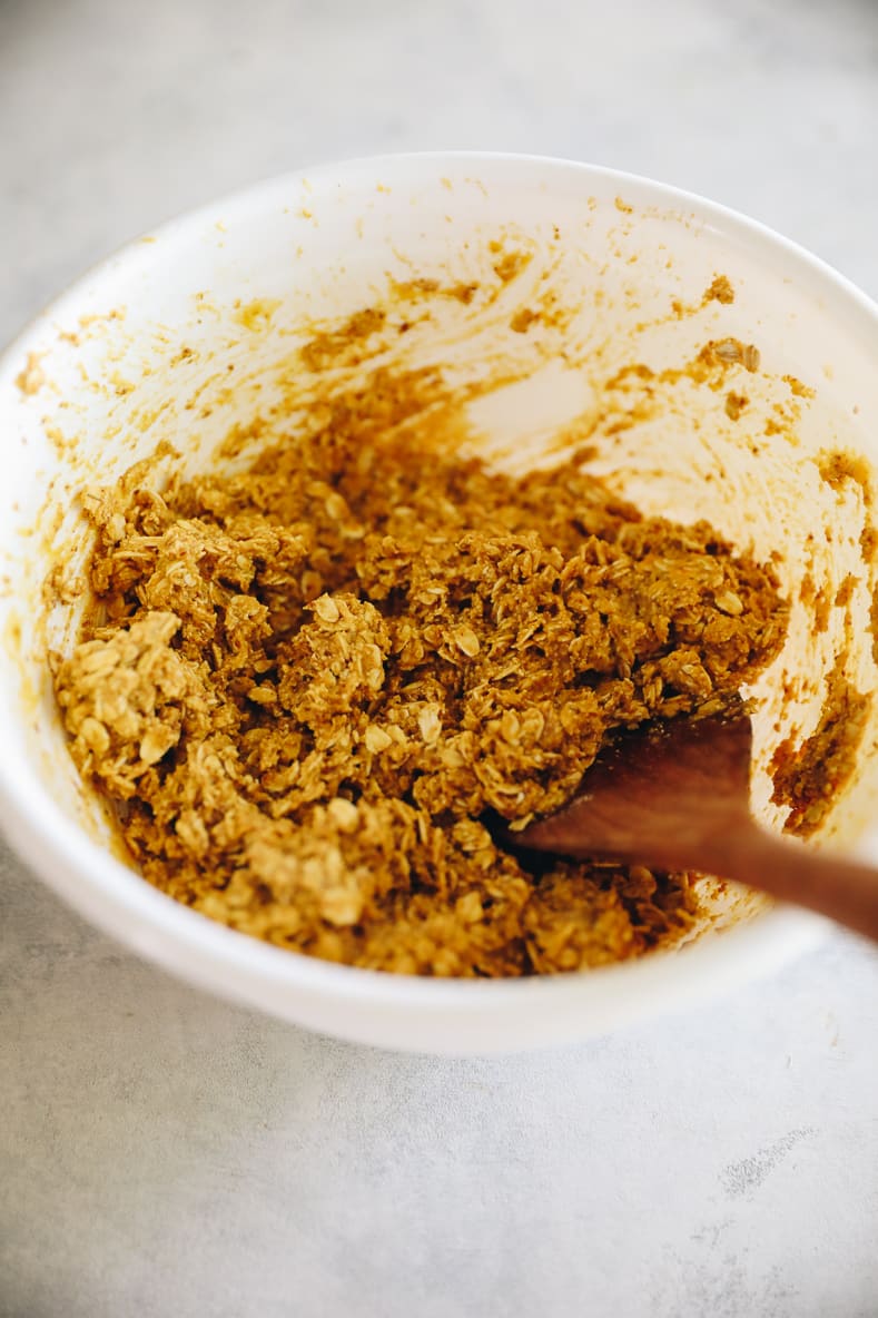 White mixing bowl with pumpkin breakfast cookie dough inside.