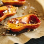 roasted honeynut squash on a parchment lined sheet pan.