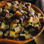 roasted Japanese sweet potato in a large brown bowl topped with a miso tahini dressing.