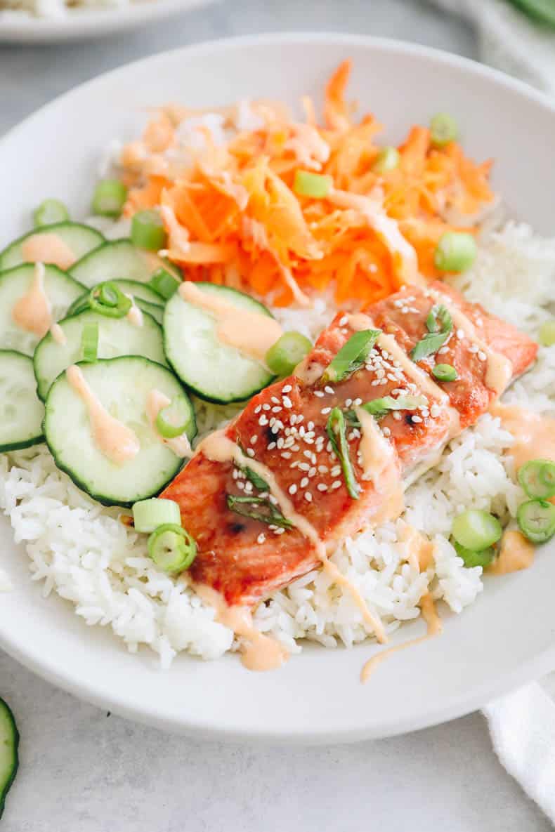 cooked miso salmon bowl recipe over rice with cucumbers, carrots, green onions and spicy mayo sauce