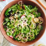 large brown bowl with spring mix salad.