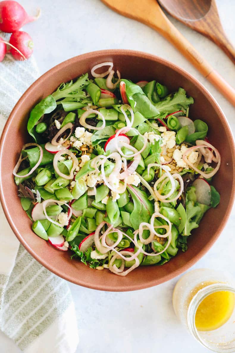 spring mix salad in a large brown bowl.