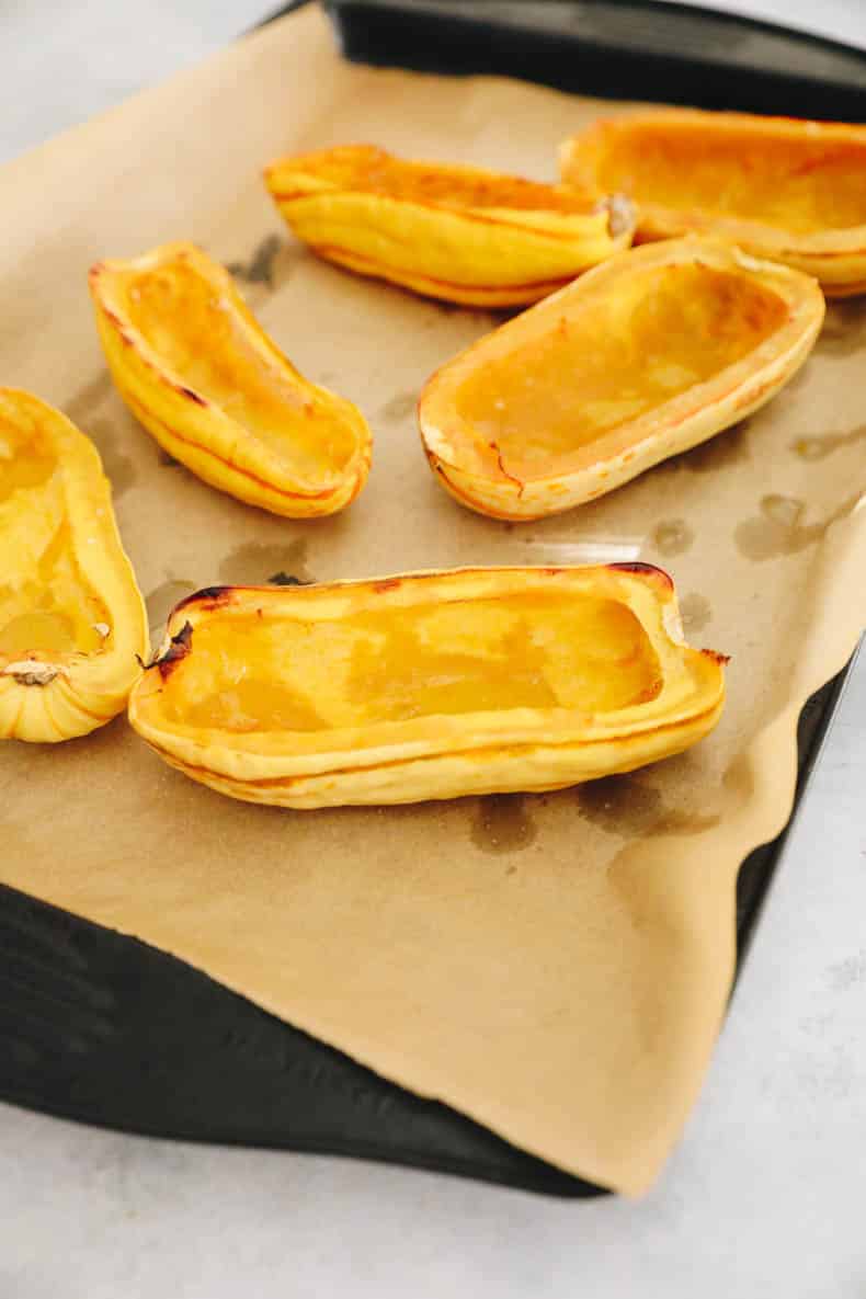 Roasted delicata squash on a sheet pan.