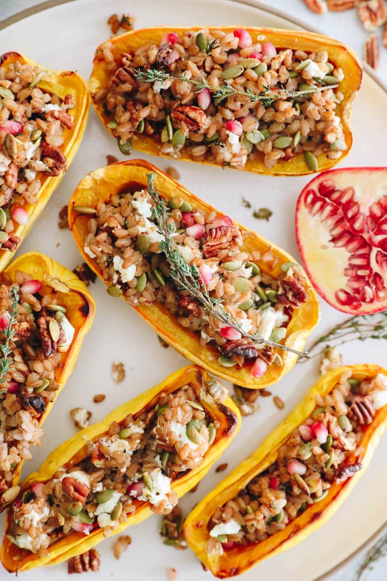 farro stuffed delicata squash with pumpkin seeds, pecans, pomegranate seeds and goat cheese.