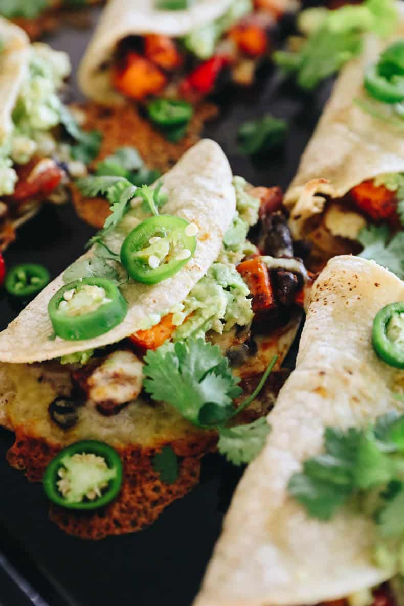 Baked black bean and sweet potato tacos topped with avocado mash, cilantro and fresh jalapenos.