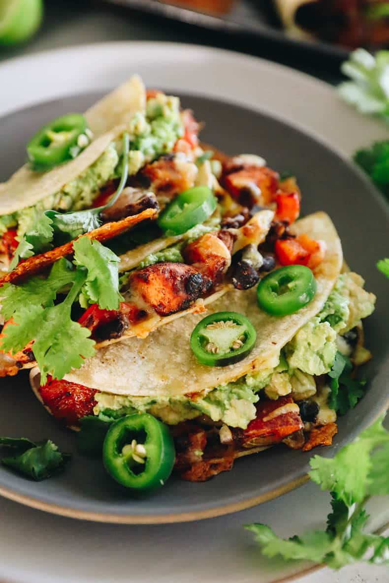 Sweet potato and black bean tacos on a blue plate with fresh cilantro