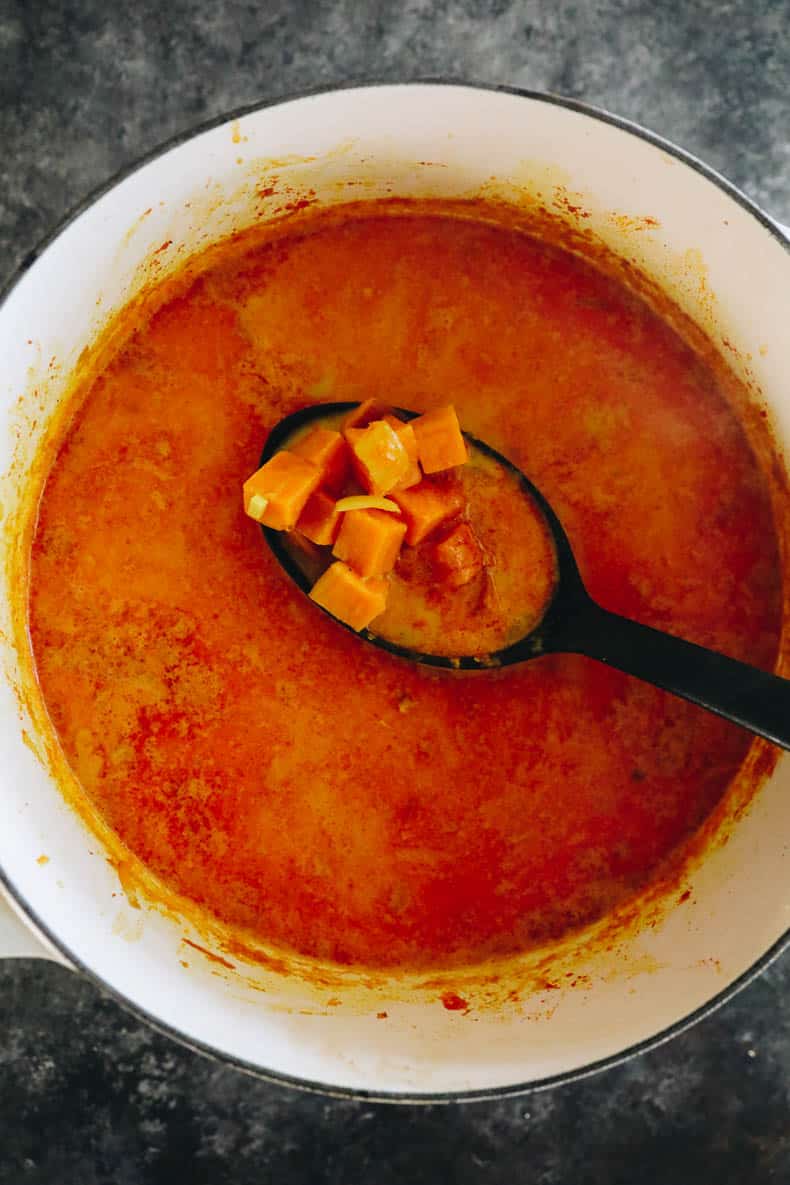 Cooked sweet potato soup in a white dutch oven.