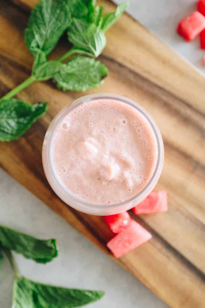 overhead image of a watermelon smoothie in a clear cup.